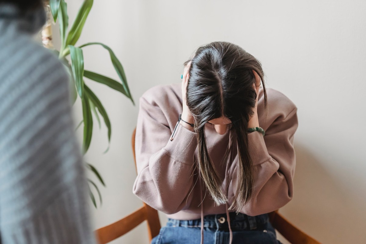 Woman sitting with her head in her hands during a therapy session